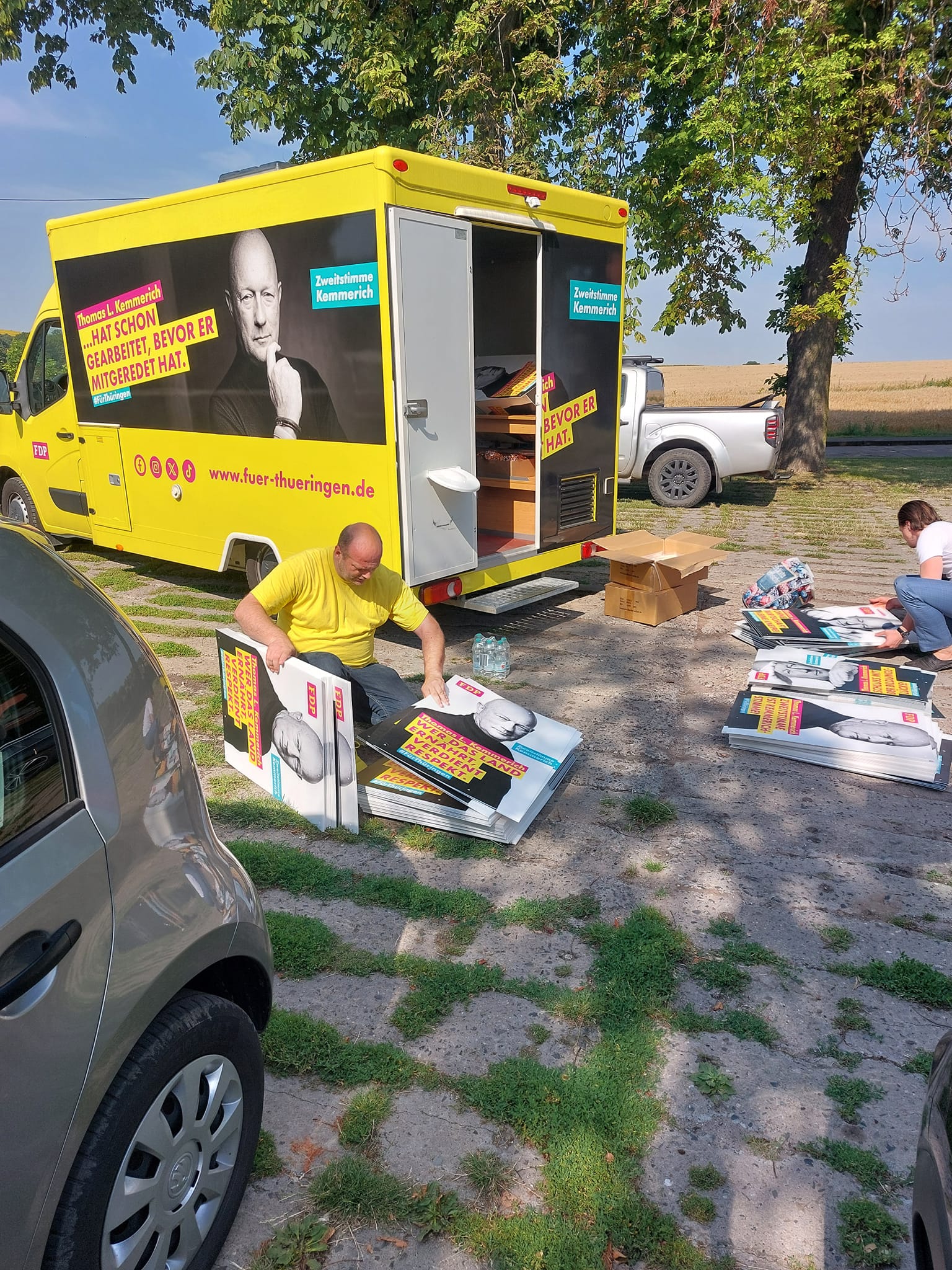 Ein Transporter in den Farben der FDP und davor die Wahlplakate liegend